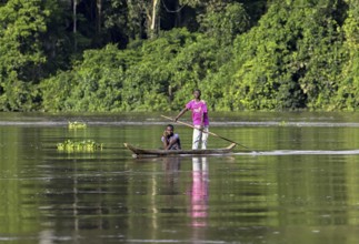 Two young men in a dugout canoe on the Sangha River, Dzanga-Sangha Complex of Protected Areas