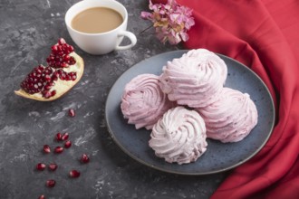 Pink pomegranate homemade zephyr or marshmallow with cup of coffee on a black concrete background