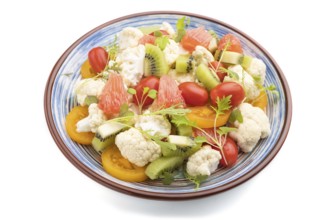 Vegetarian salad of cauliflower cabbage, kiwi, tomatoes, microgreen sprouts isolated on white