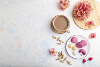 Purple macarons or macaroons cakes with cup of coffee on a white concrete background decorated with