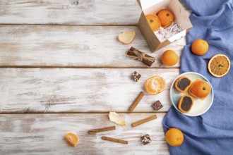 Truffle chocolate tangerine candies on a white wooden background and blue linen textile. top view,