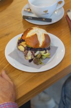 A burger on a pretzel bun with a napkin on a plate, autumn creations, Cafe Kuh, Deckenpfronn, Black