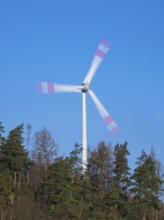 Wind Turbine, on a ridge in a forest, taken with a long exposure to create an abstract blurred