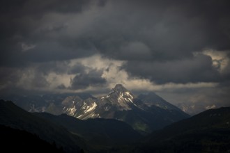 Summit of the Biberkopf with remnants of snow and dramatic clouds, Lech, Lechquellengebirge,