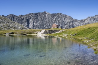 Rocky mountain peaks of the Panargenkamm and mountain hut Neue Reichenberger Hütte with mountain