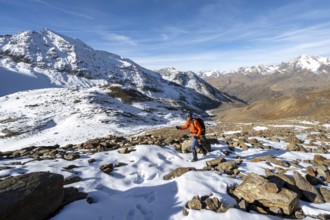 Mountaineer on a hiking trail with snow, descent from Ramoljoch at Spiegelferner, autumnal mountain