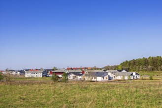 Newly built residential area with detached residential houses and apartment buildings and land to