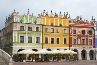 Historic Renaissance houses with colourful facades in a lively market scene, Great Market, Zamosc,