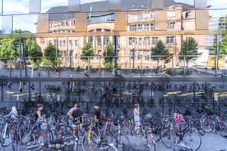 Bicycles parked in front of the reflecting facade of the University Library Freiburg im Breisgau,