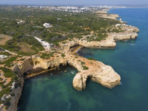 Coastline with rocky cliffs and green vegetation, fringing the blue sea, aerial view, Arco de