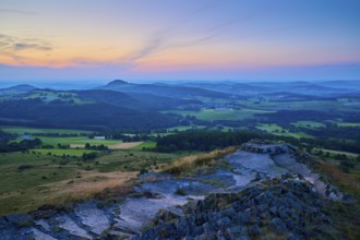 Hilly landscape at dusk with colourful sky and meadows in the foreground, Abtsroder Kuppe,