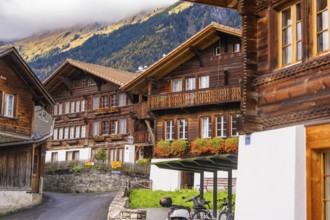 Village street with traditional wooden houses in the Alps against a mountain backdrop, Lake Brienz,