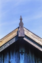 Gable and the rooftop on an old wooden cottage with a cross on the wall, Sweden, Europe