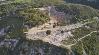 Drone shot, first morning light, Aerial view of ancient ruins surrounded by green hills and lush