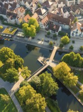 Aerial view of houses with red roofs, a river with a bridge and many trees, Nagold, Black Forest,