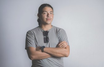 Smiling latin young man with crossed arms isolated, looking at camera