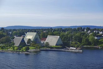 Modern buildings by the water, surrounded by trees and under a clear sky, Bygdøy museum peninsula,