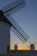 Close-up of a windmill in the foreground with two others on the horizon at sunset, windmills, Campo