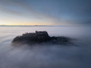 Aerial view of the Hegau volcano Hohentwiel with the upper fortress ruins in front of sunrise,