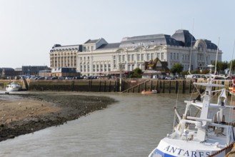 Large historic riverside building with boats in the foreground, Casino Barrière, casino,