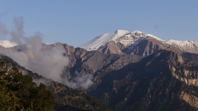 Mountains with snow-covered peaks and some clouds in a calm, natural atmosphere, Omalos Plateau,