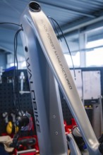 Grey bicycle frame with Waldbike branding in a well-lit workshop, Waldbike Manufaktur, bicycle