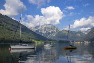 Sailing boats on Lake Achensee with the village of Pertisau, behind them the Karwendel mountains,