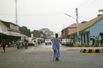 People and cars in a busy street in the central business district, Banjul, Gambia, Africa, 1978,