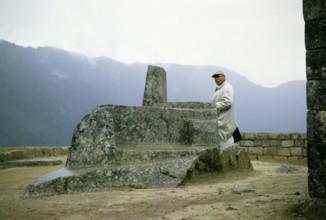 Male tourist at the Intihuatana sundial stone, Machu Picchu, Peru, South America, around 1962,