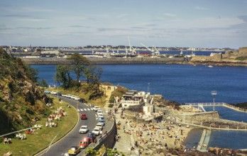 Menschen beim Sonnenbaden an der Küste, St. Peter Port, Guernsey, Kanalinseln, Großbritannien, Juni