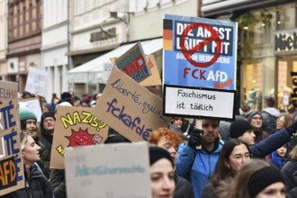 Heidelberg, Germany - February 12th 2025: Young people holding up signs in crowd at protest against