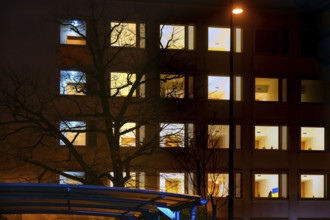 Evening facade of the university hospital with illuminated rooms, Erlangen, Middle Franconia,