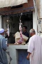 Men in a butcher's shop processing meat in a small shop, At the Tichka Pass, Col du Tichka, 2260m,