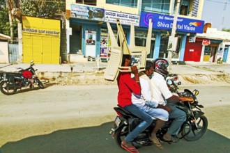 Man carrying plastic chairs on bike, Hubli, Dharwad, Karnataka, India, Asia