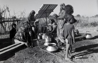 Woman collecting water from solar energy operated water pump, madhya pradesh, India, Asia