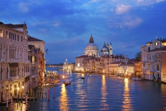 View of Venice Grand Canal with boats and Santa Maria della Salute church in the evening from Ponte