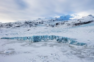 Snow-covered icebergs in the Fjallsarlon glacier lagoon, with the Öraefajökull glacier behind,