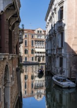 Gondola travelling through a small canal, reflection, Venice, Italy, Europe