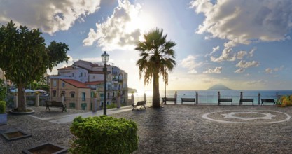 Belvedere Piazza del Cannone town square with the sun at its lowest and the Stromboli volcano in