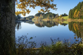 The Hengelesweiher pond in the Hengelesweiher nature reserve in autumn. The lake is surrounded by