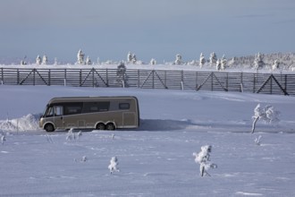 Winter camping with camper van on a mountain near Saariselkä, Lapland, Finland, Europe