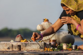 MAHESHWAR, INDIA, APRIL 26: Indian woman performs morning pooja on sacred river Narmada ghats on