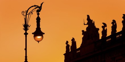 Old Berlin gas lantern in the street Unter den Linden at sunset at the German Historical Museum,