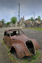 Burnt-out Peugeot 202 of family doctor Desourteux on the street The burnt-out village of