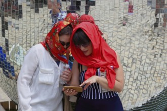 Two girls with red headscarves, sunglasses and mobile phones, Kiev, Ukraine, Europe