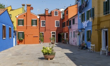 Colourful houses with flowers, colourful house facades, alleys on the island of Burano, Venice,