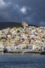 View of the town of Ermoupoli with pastel-coloured houses and the sea, on the hill Anastasi Church