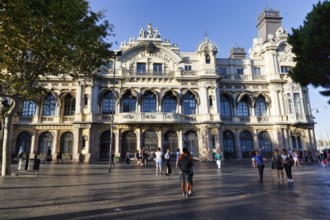 Pedestrians in front of the historical building of the port authority, Port de Barcelona, city