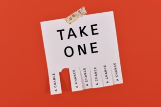 Tear-off stub note with text 'Take a chance' on red background