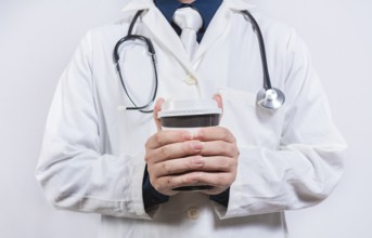 Hands of doctor holding takeaway coffee on isolated background. Doctor hands holding paper coffee